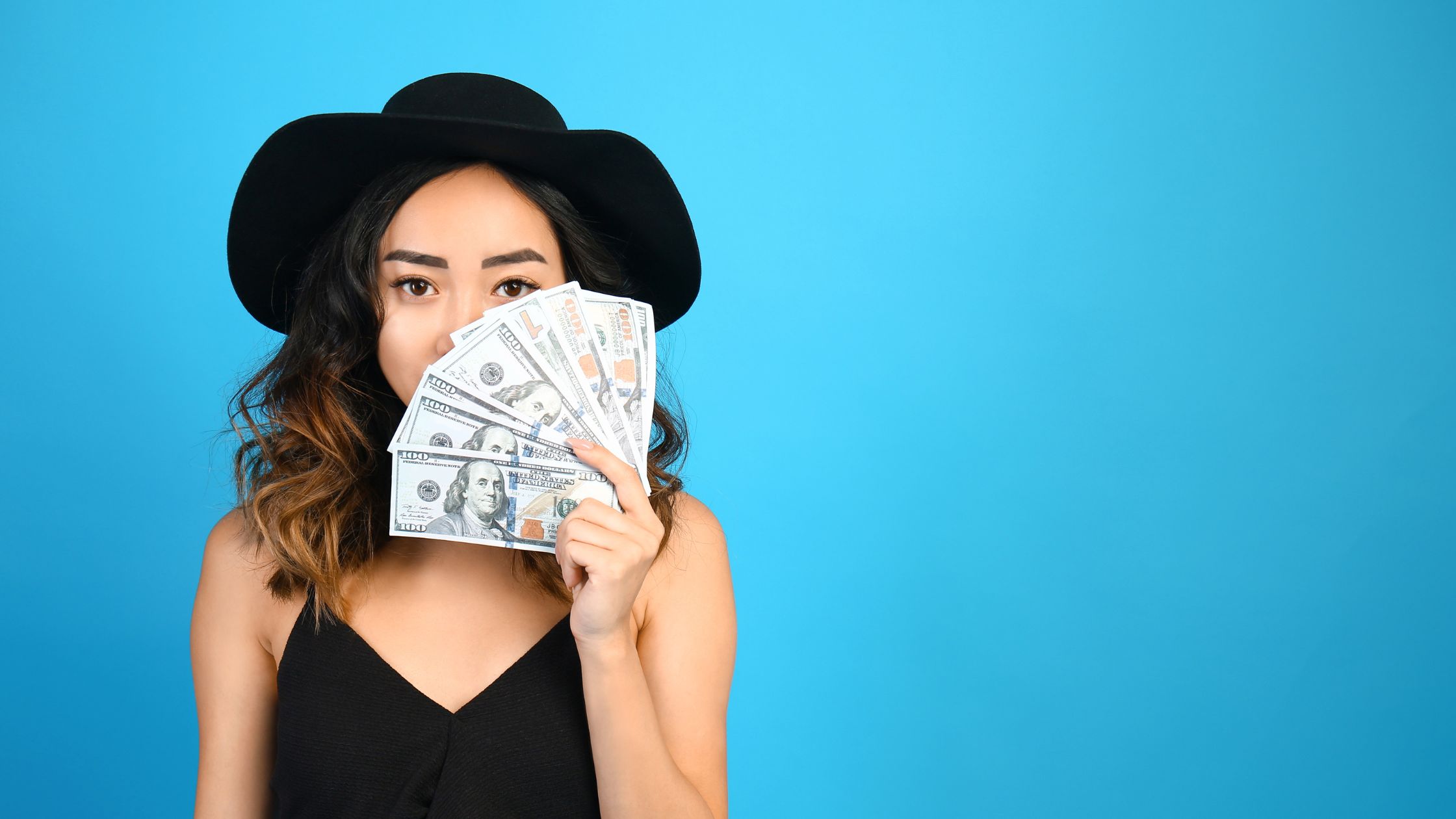 Frau mit Geldscheinen vor blauem Hintergrund
